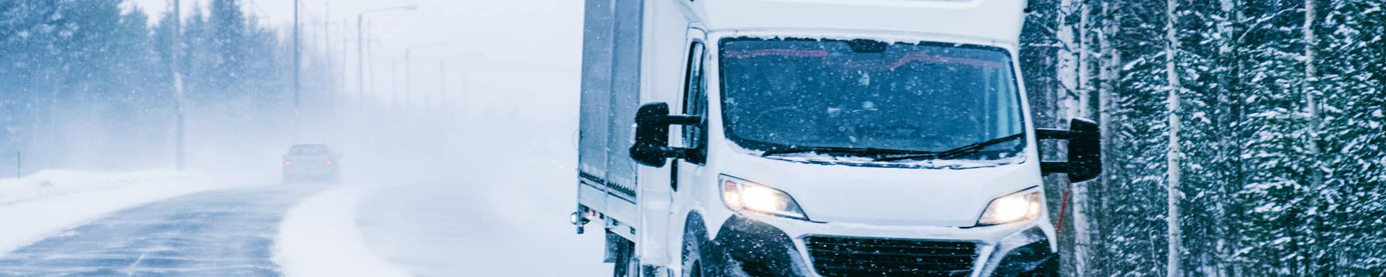 Van driving down snowy road in North Wales