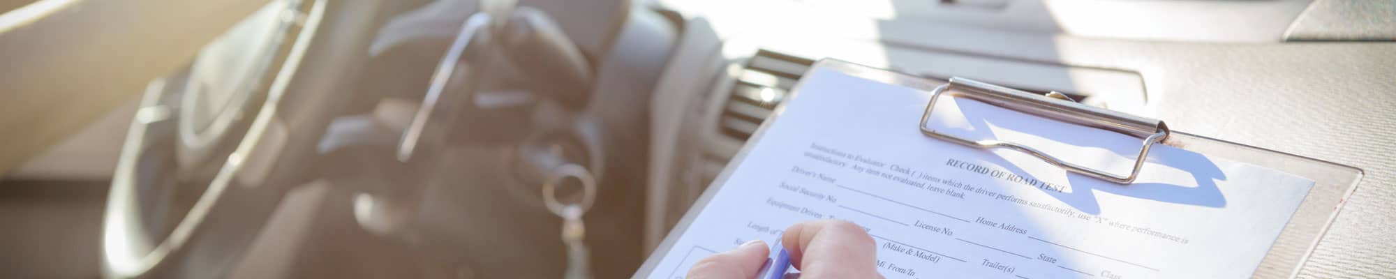 Driving examiner making notes during lesson