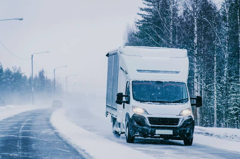 Van driving down snowy road